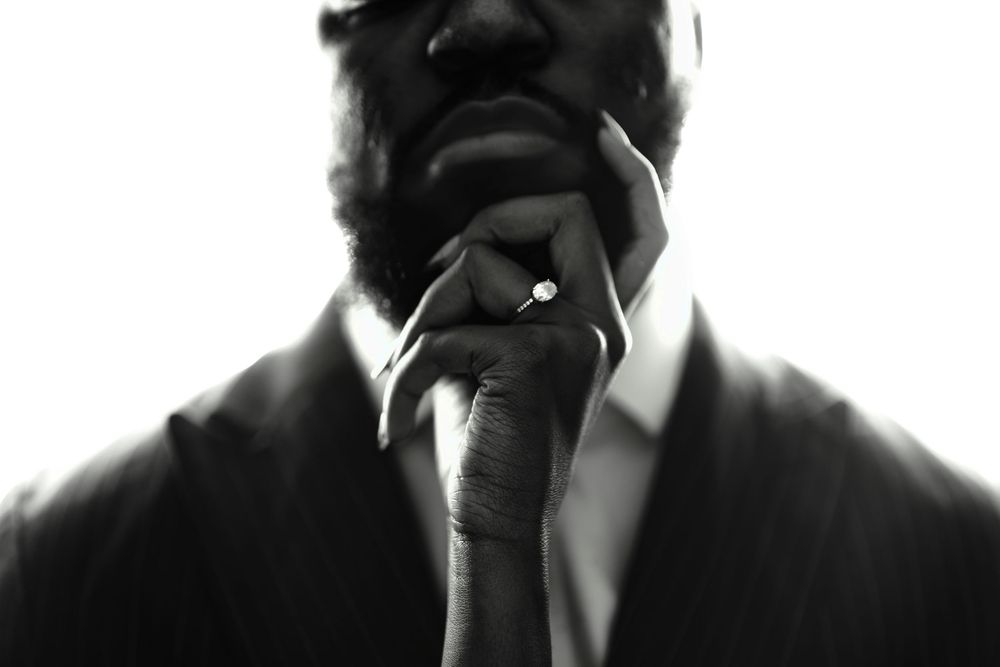 Black and white portrait of four people in business attire standing together in formal poses.
