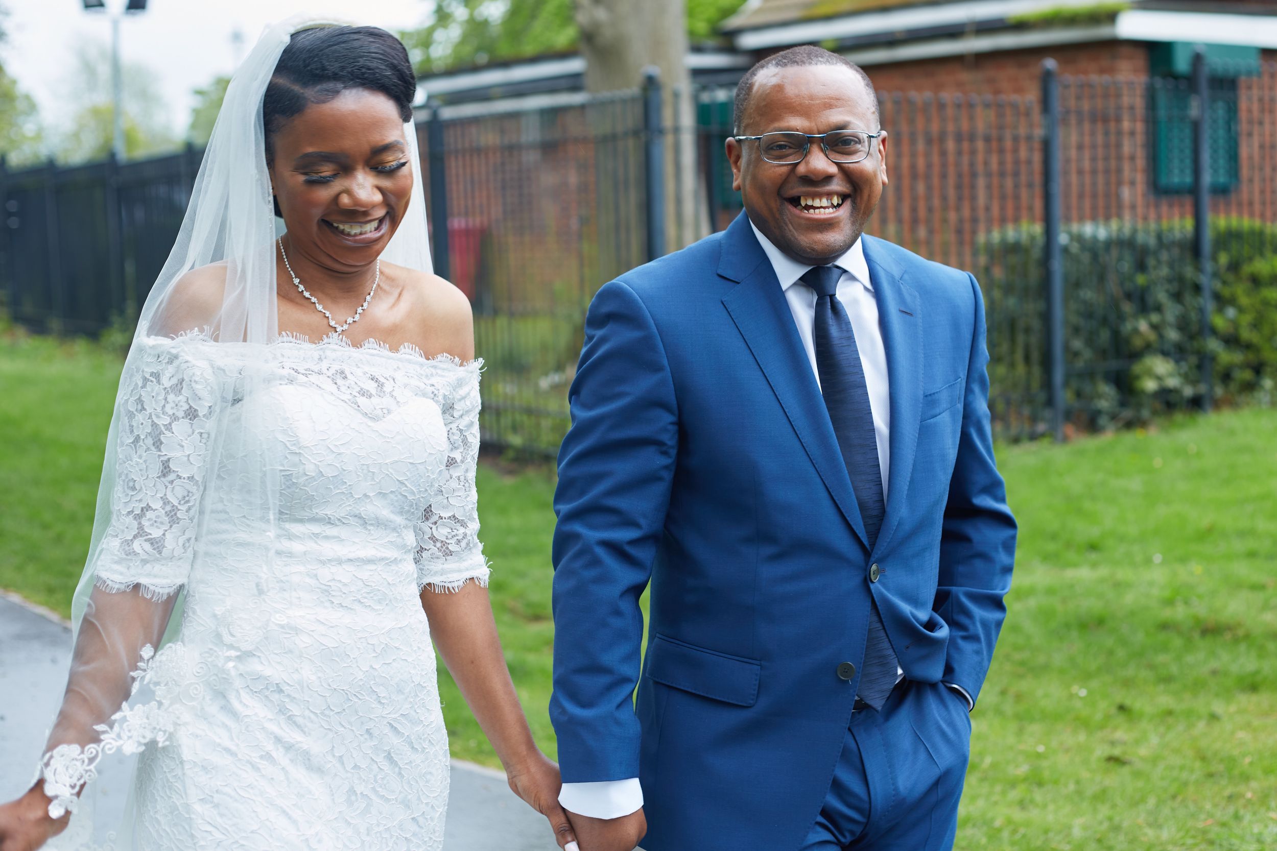 Happy wedding couple in formal attire posing outdoors on their special day.
