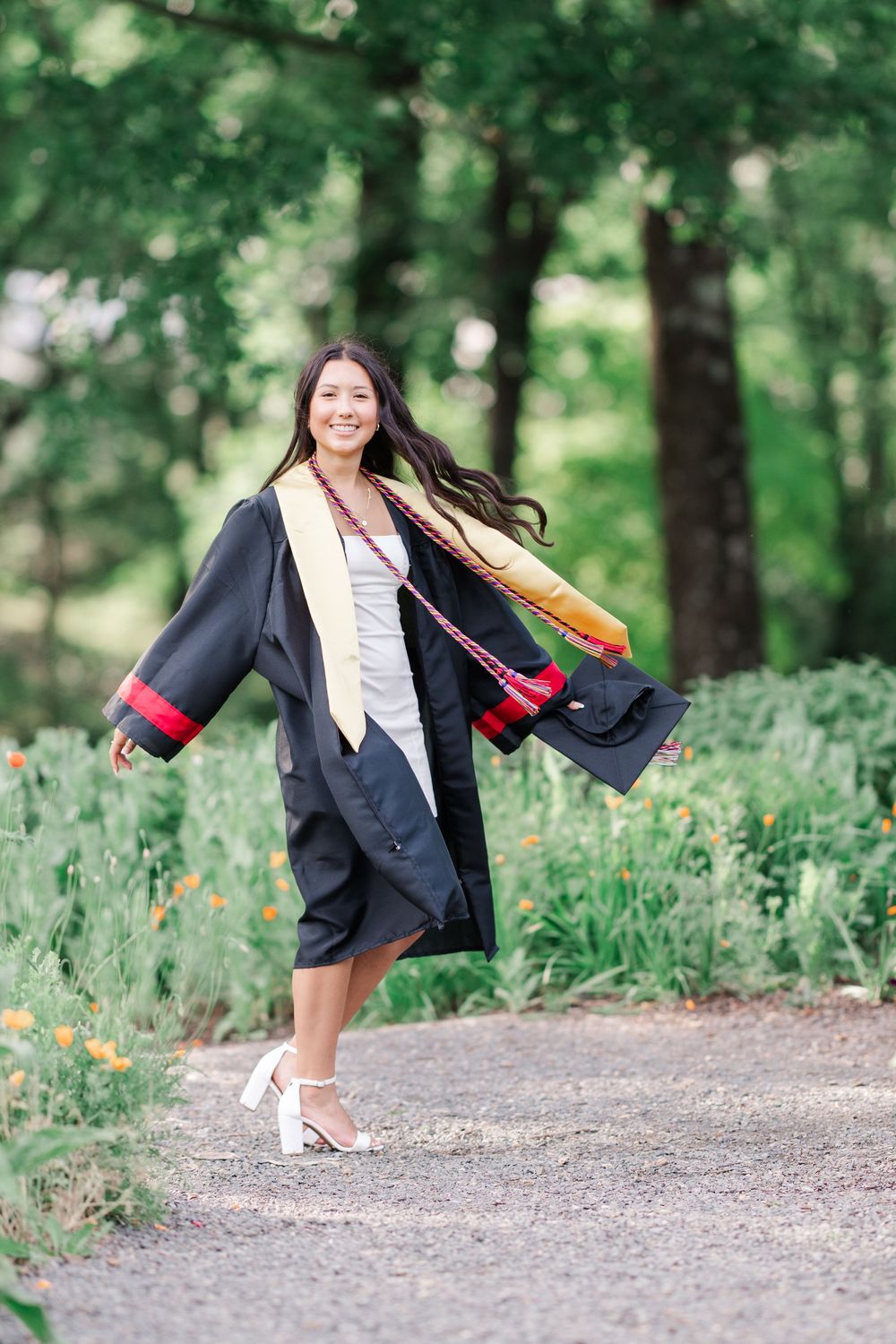 Cap and Gown clad senior in Meadowlark Gardens in Vienna, Virginia