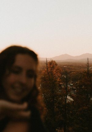 Sunset mountain landscape with fall foliage and blurred figure in foreground.