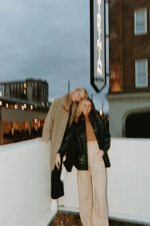 Nighttime urban fashion portrait with vintage lighting and architectural backdrop.