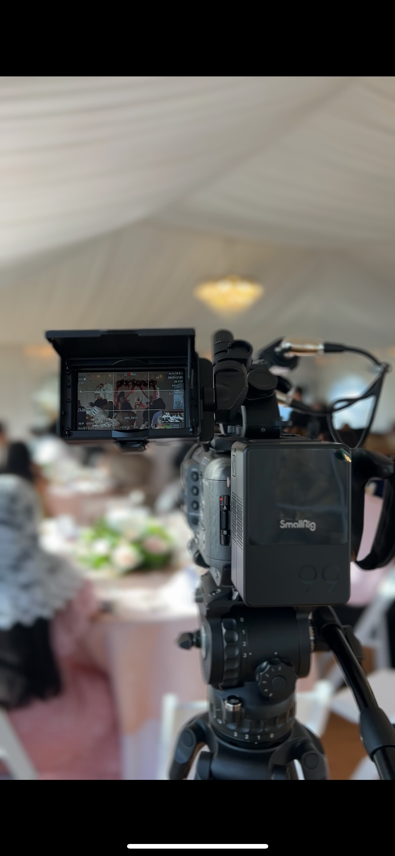Professional video camera setup with SmallRig equipment filming at an indoor event.