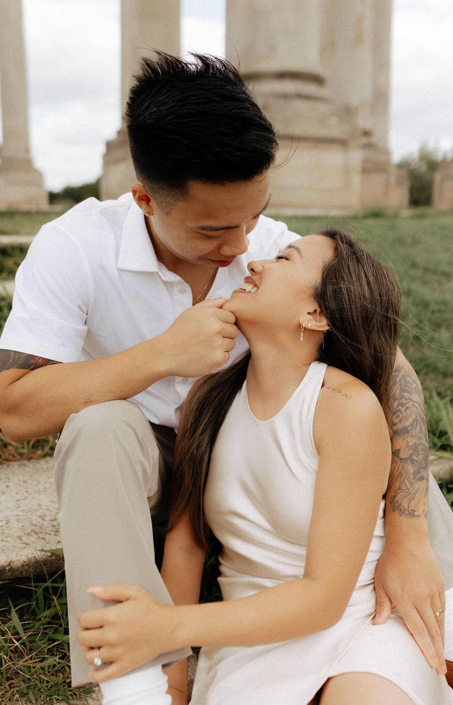 Romantic couple embracing outdoors in autumn setting wearing casual attire.