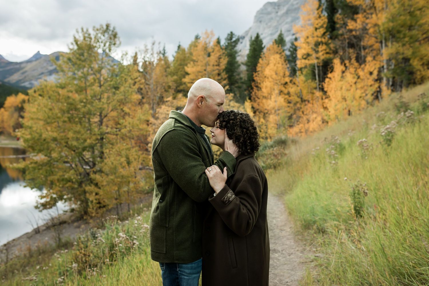 Couple kissing during fall engagement photography session in Kananaskis mountains near Calgary