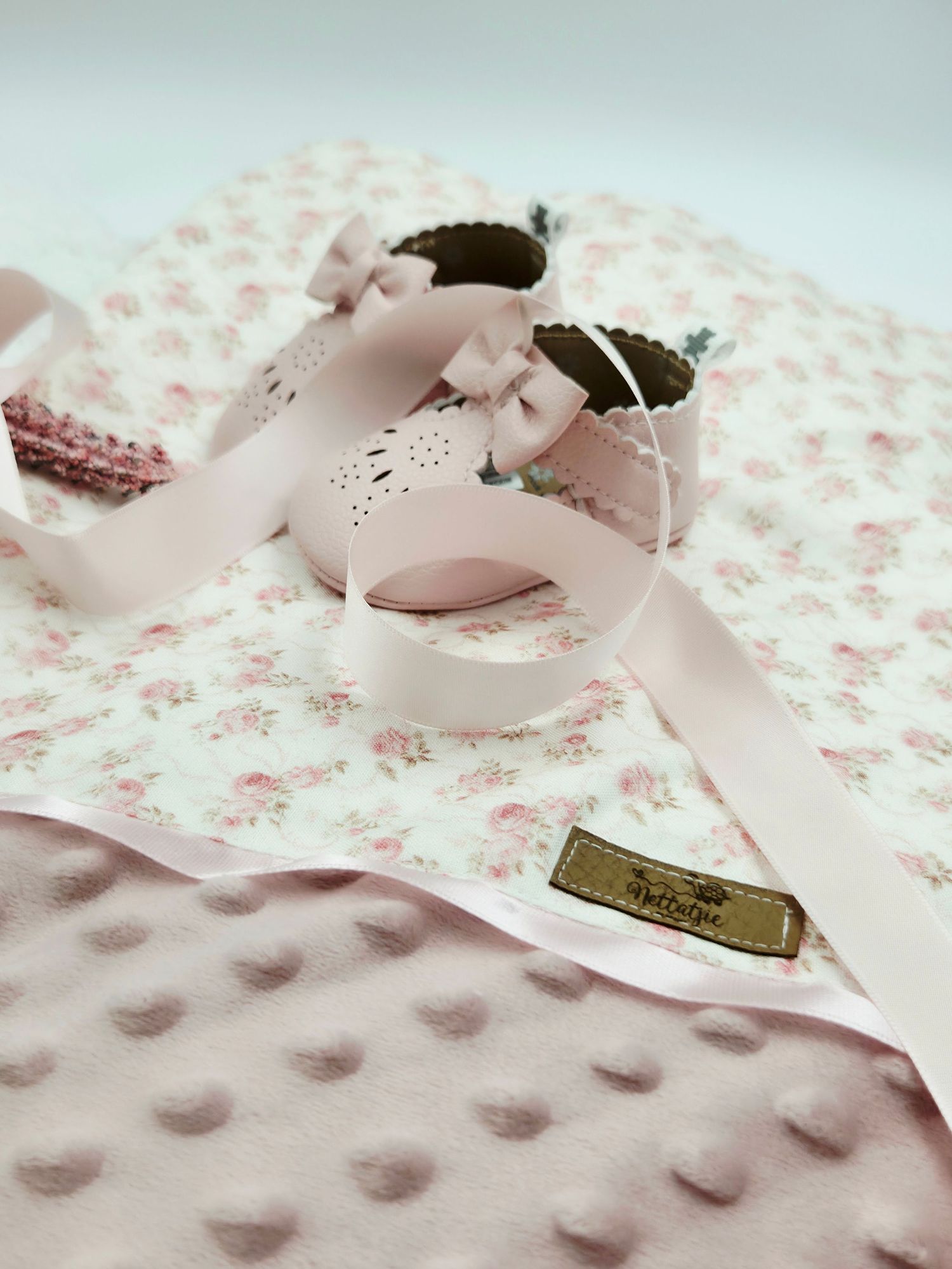 Pink floral and textured minky fabric with a satin bow detail.