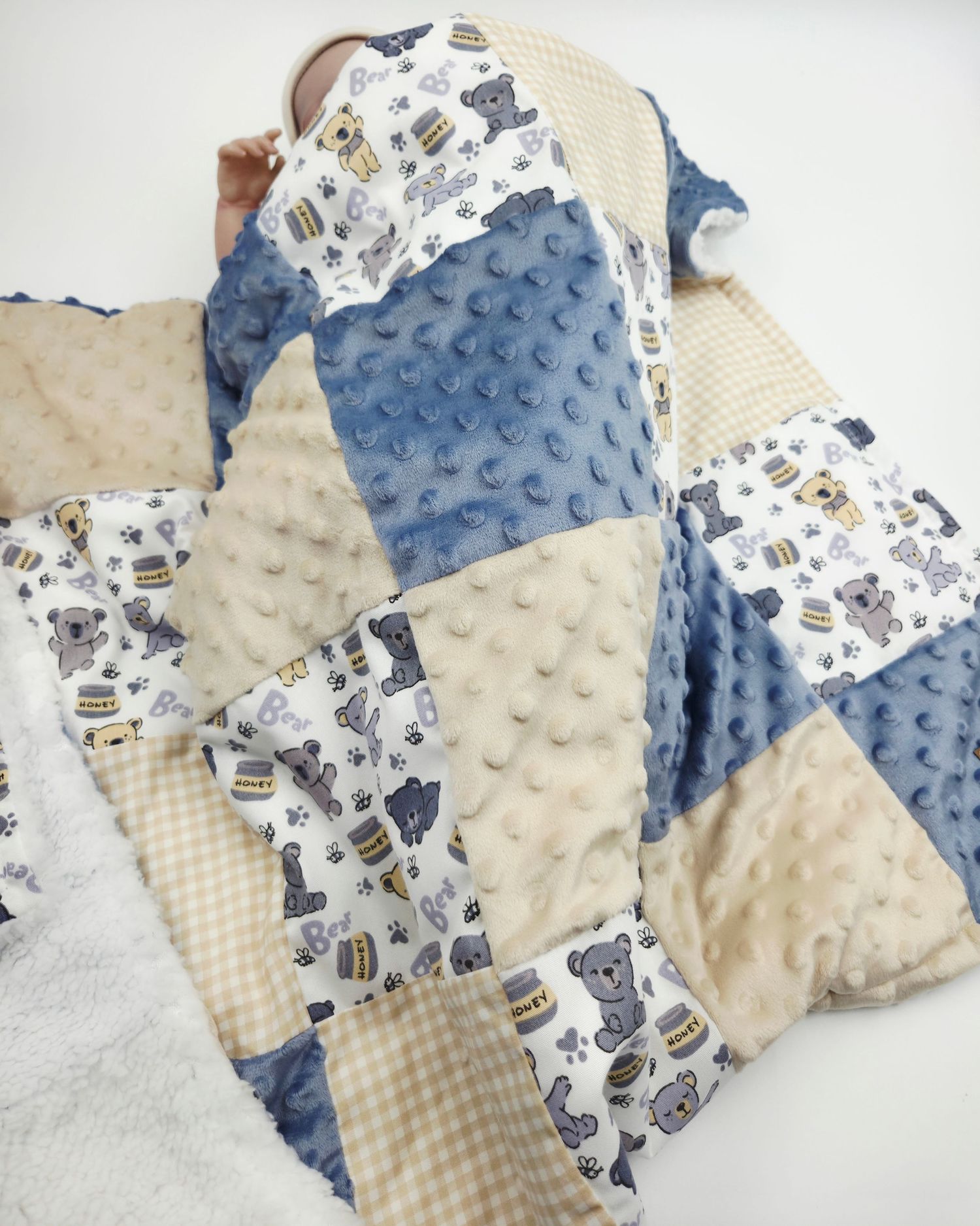 Textured minky patchwork blanket featuring blue, cream and animal print squares.