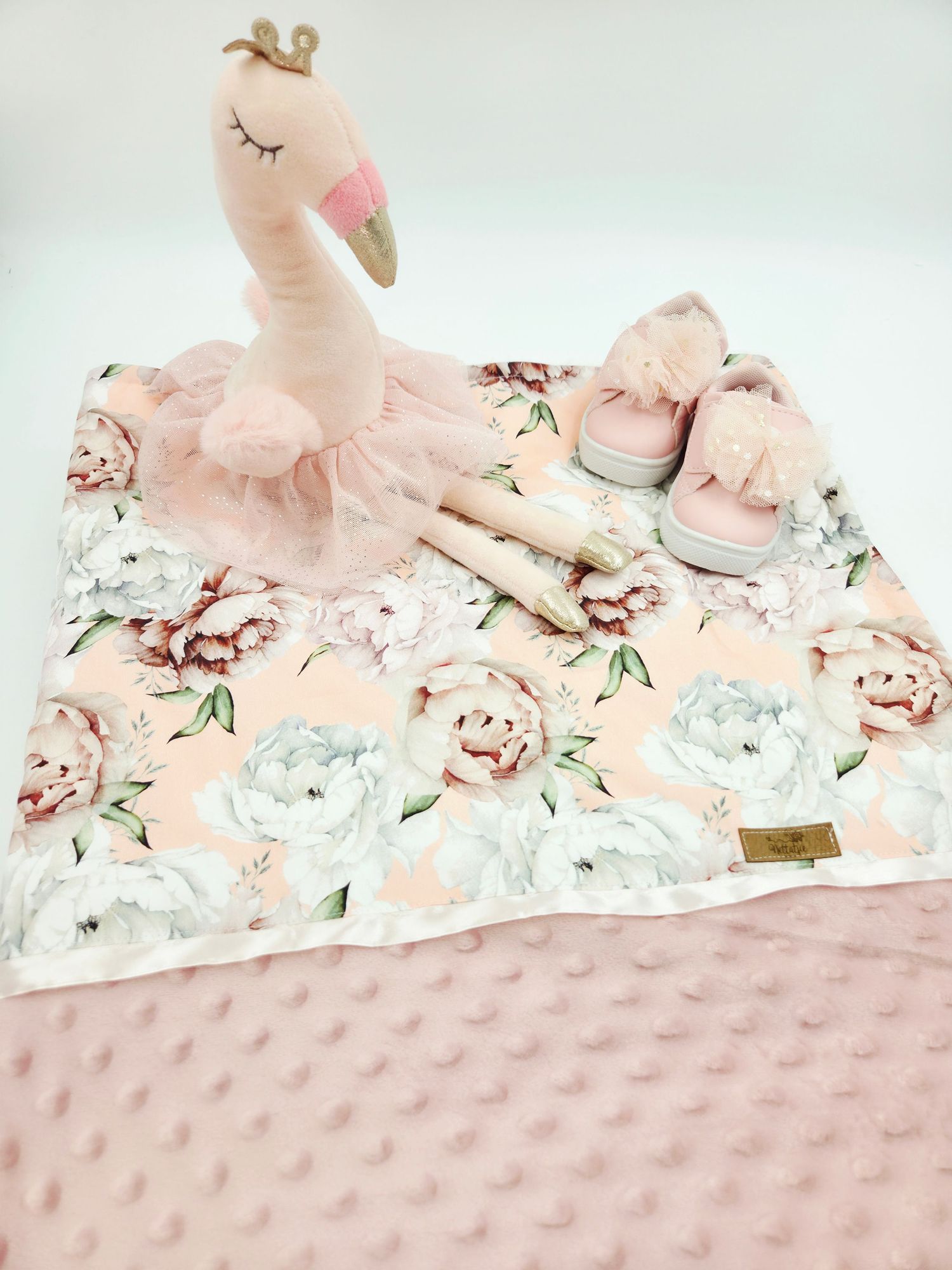 Pink floral and minky blanket with plush toy displayed on white background.