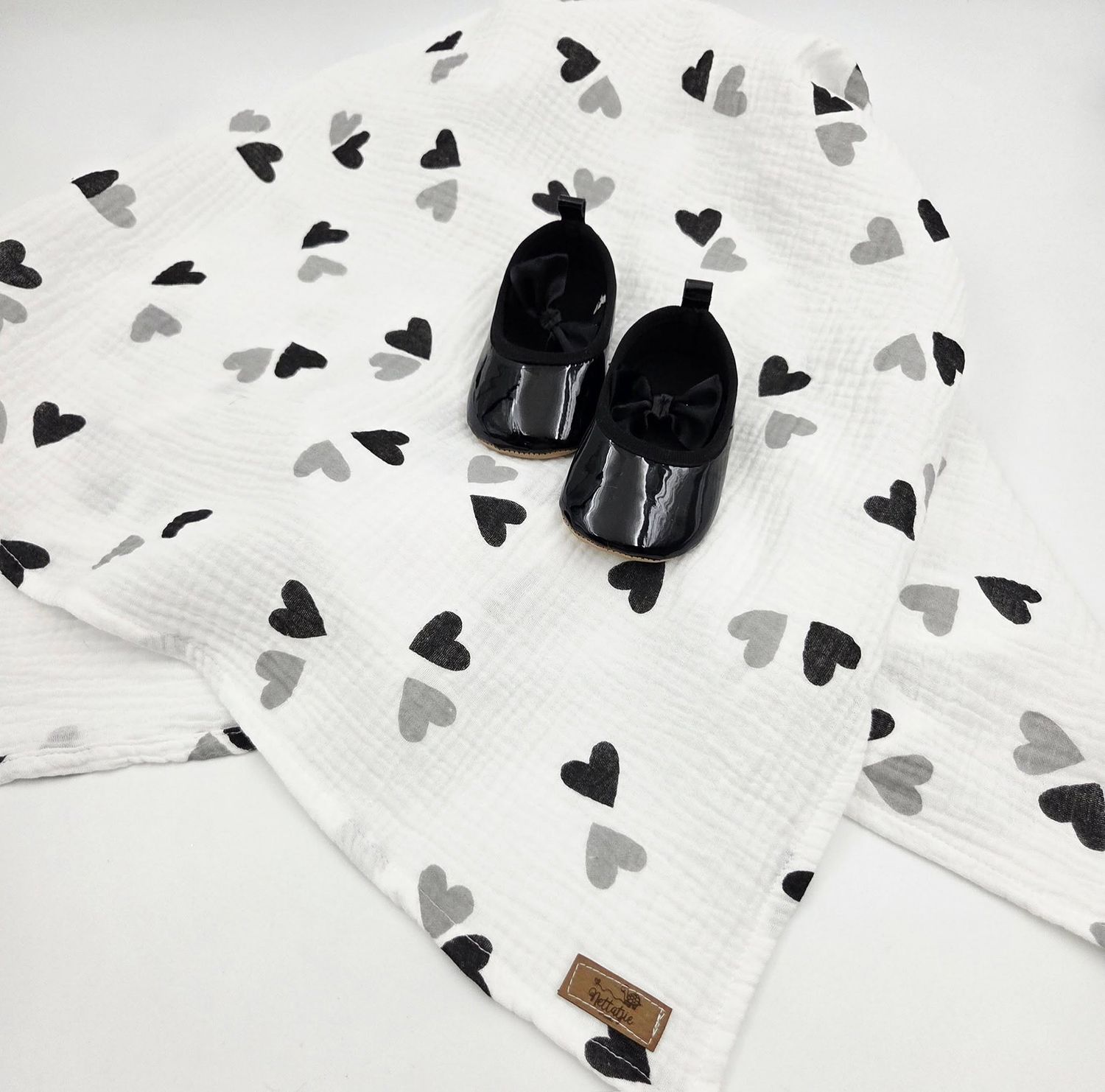 White baby blanket with black and gray heart pattern displayed across multiple angles.