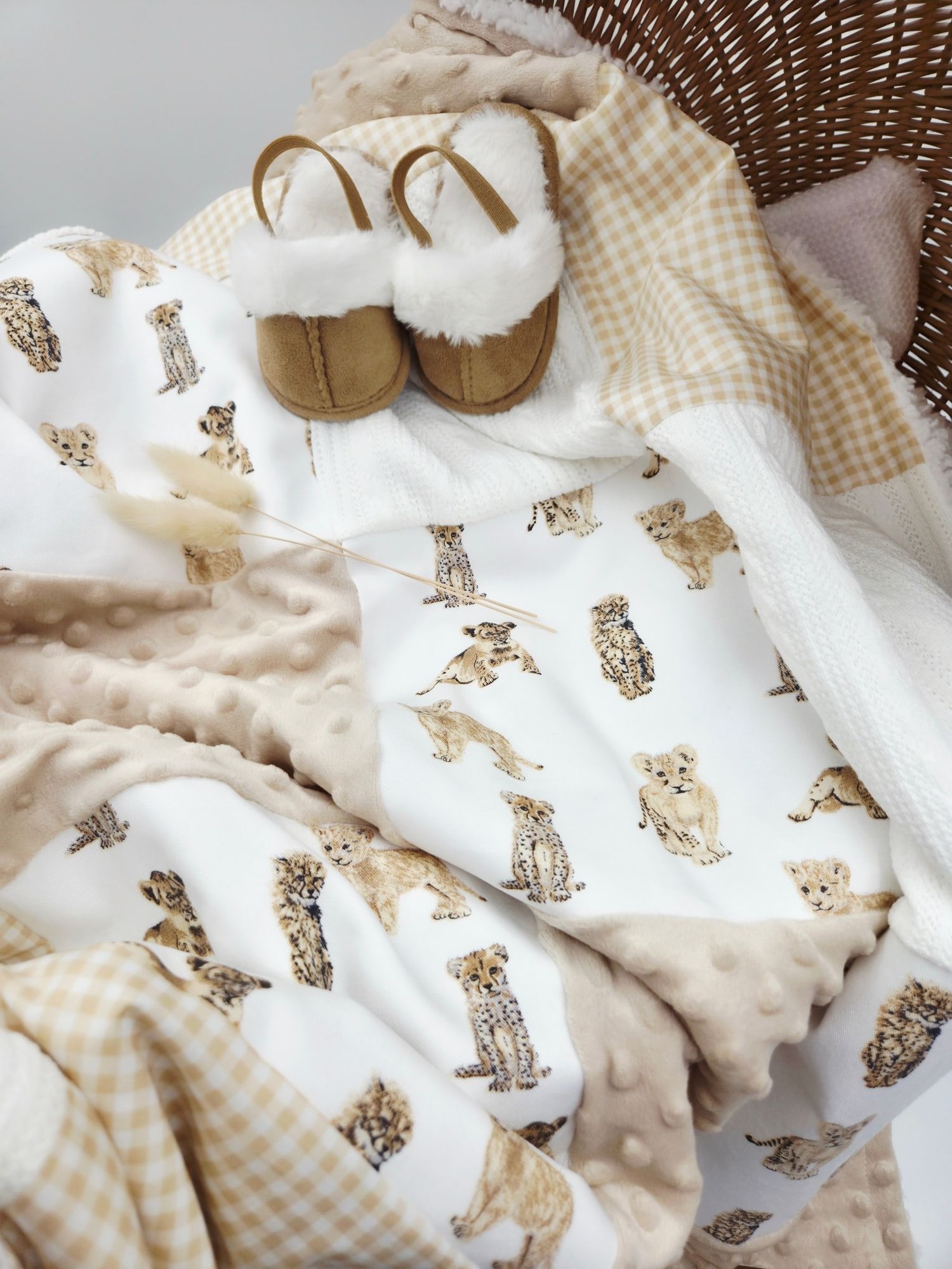 Cozy beige and white baby blanket set with puppy print design displayed in wicker basket.