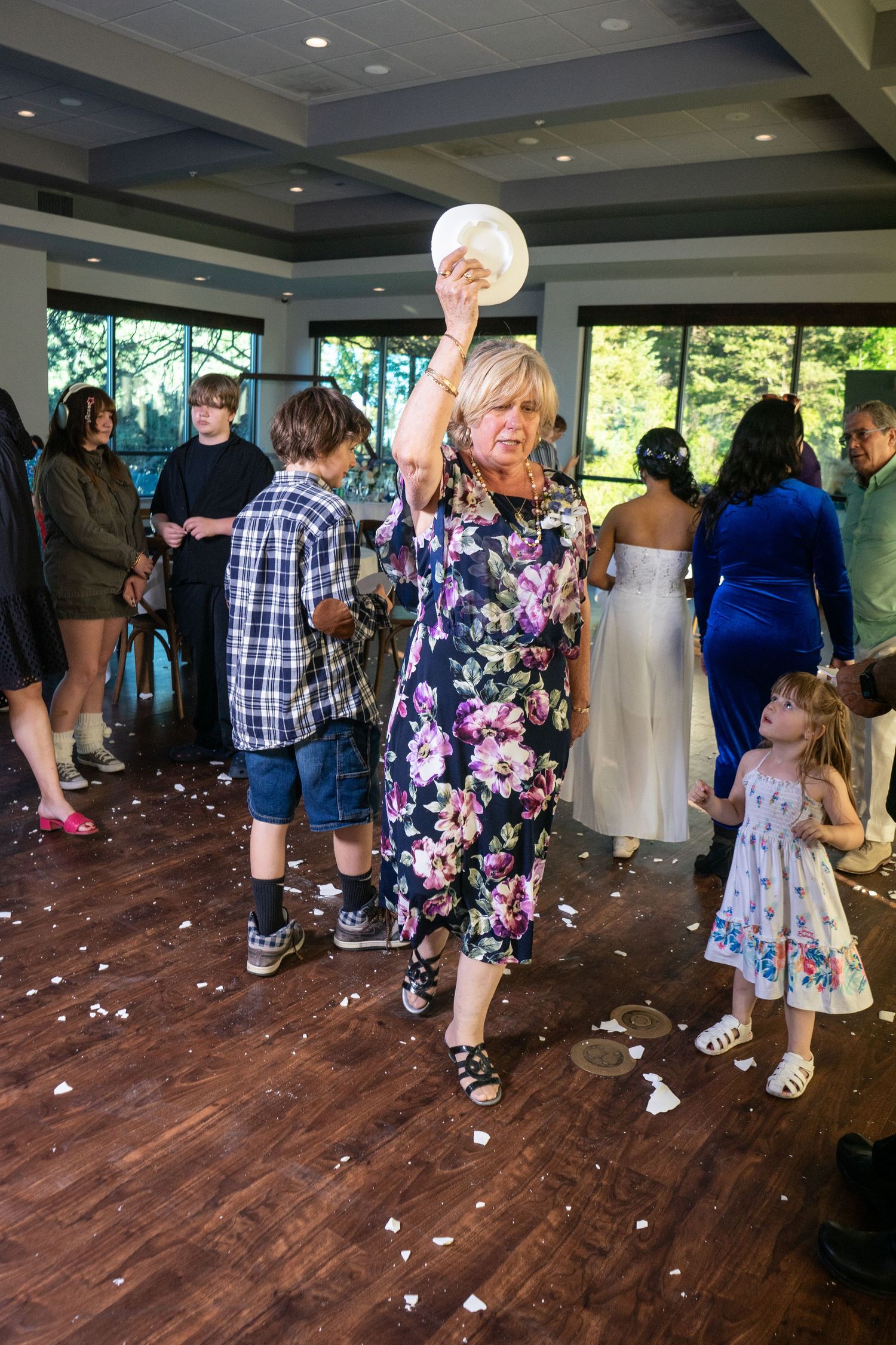 Candid photograph of traditional Greek plate smashing at a wedding reception