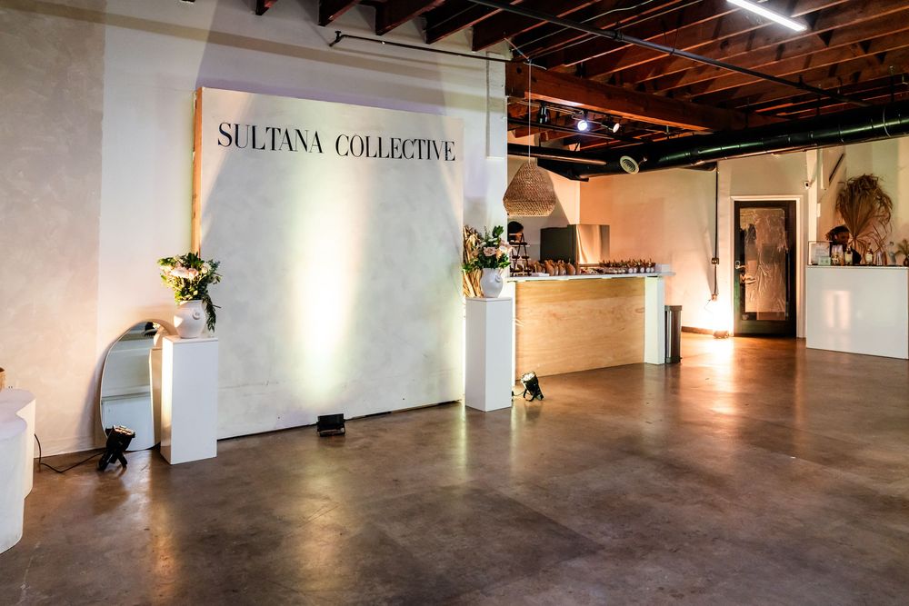Modern retail space with concrete floors and Sultana Collective branding on white walls.