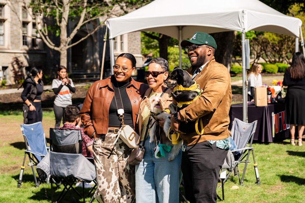 Festival attendees enjoying a sunny day under white canopy tents.