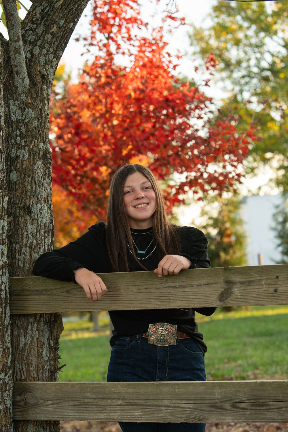 Autumn portrait series with wooden fence and vibrant red maple trees.
