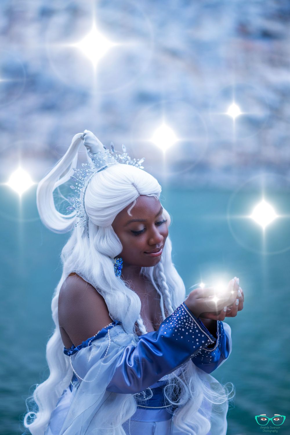 Magical winter-themed portrait with glowing orbs and sparkling effects against a blue backdrop.
