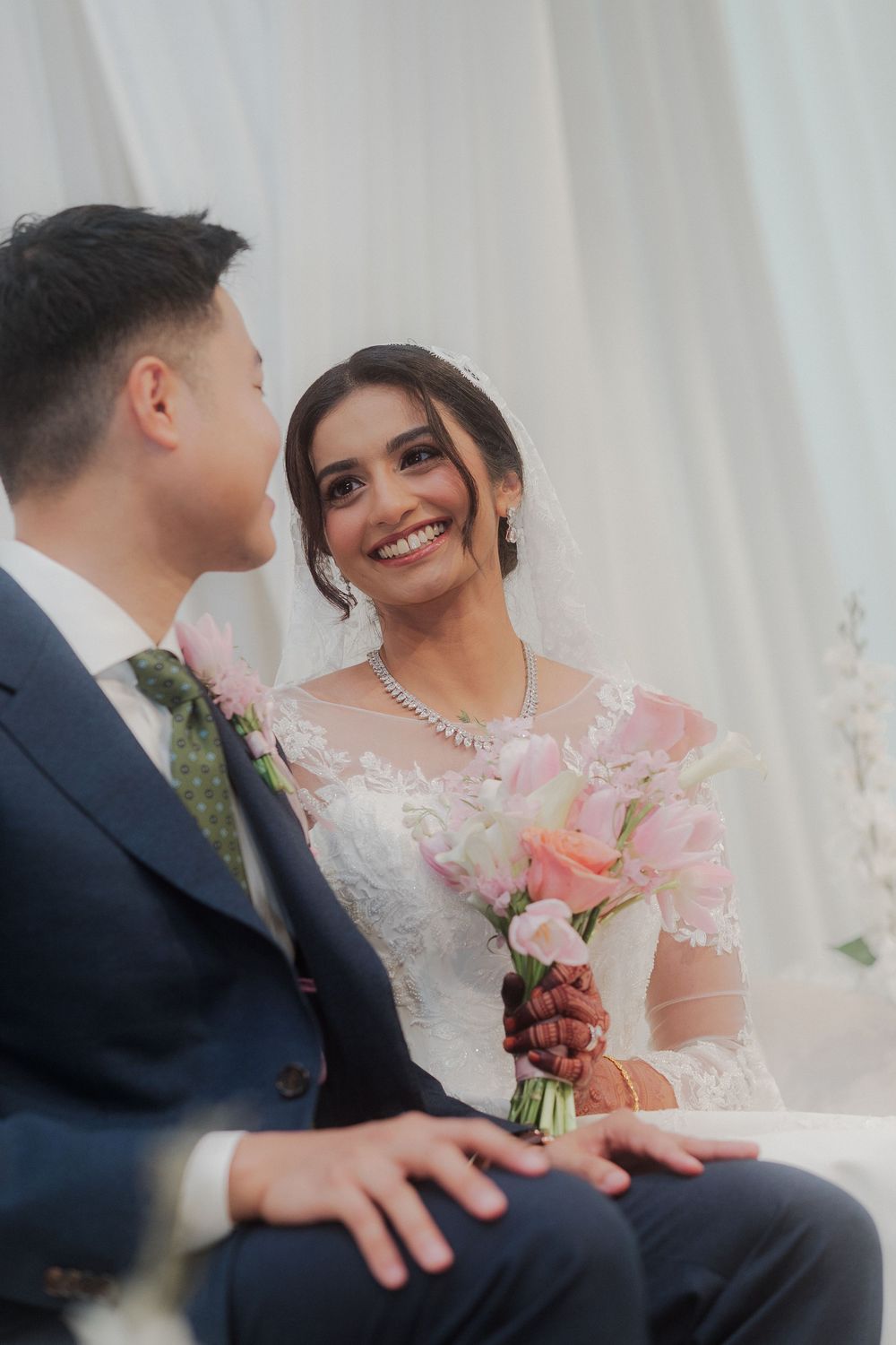 Candid wedding moments captured against white backdrop with pink floral accents.