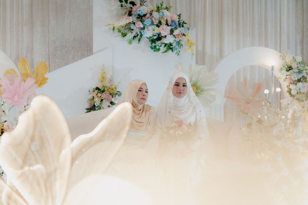 An elegant wedding venue decorated with soft white drapes and floral arrangements.