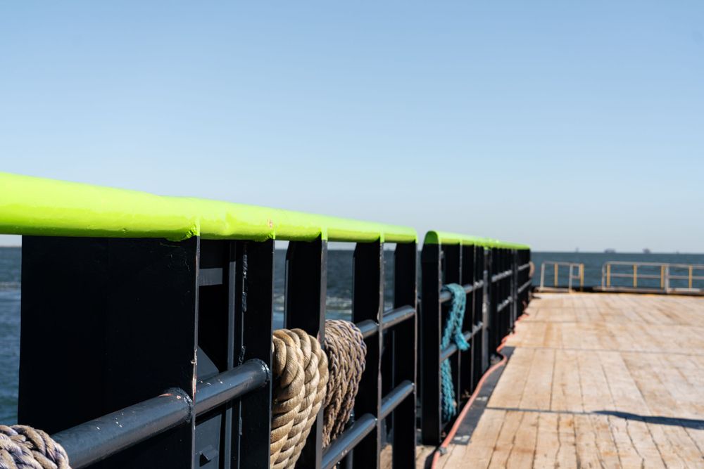 A wooden pier or dock extends into the ocean under clear blue skies.