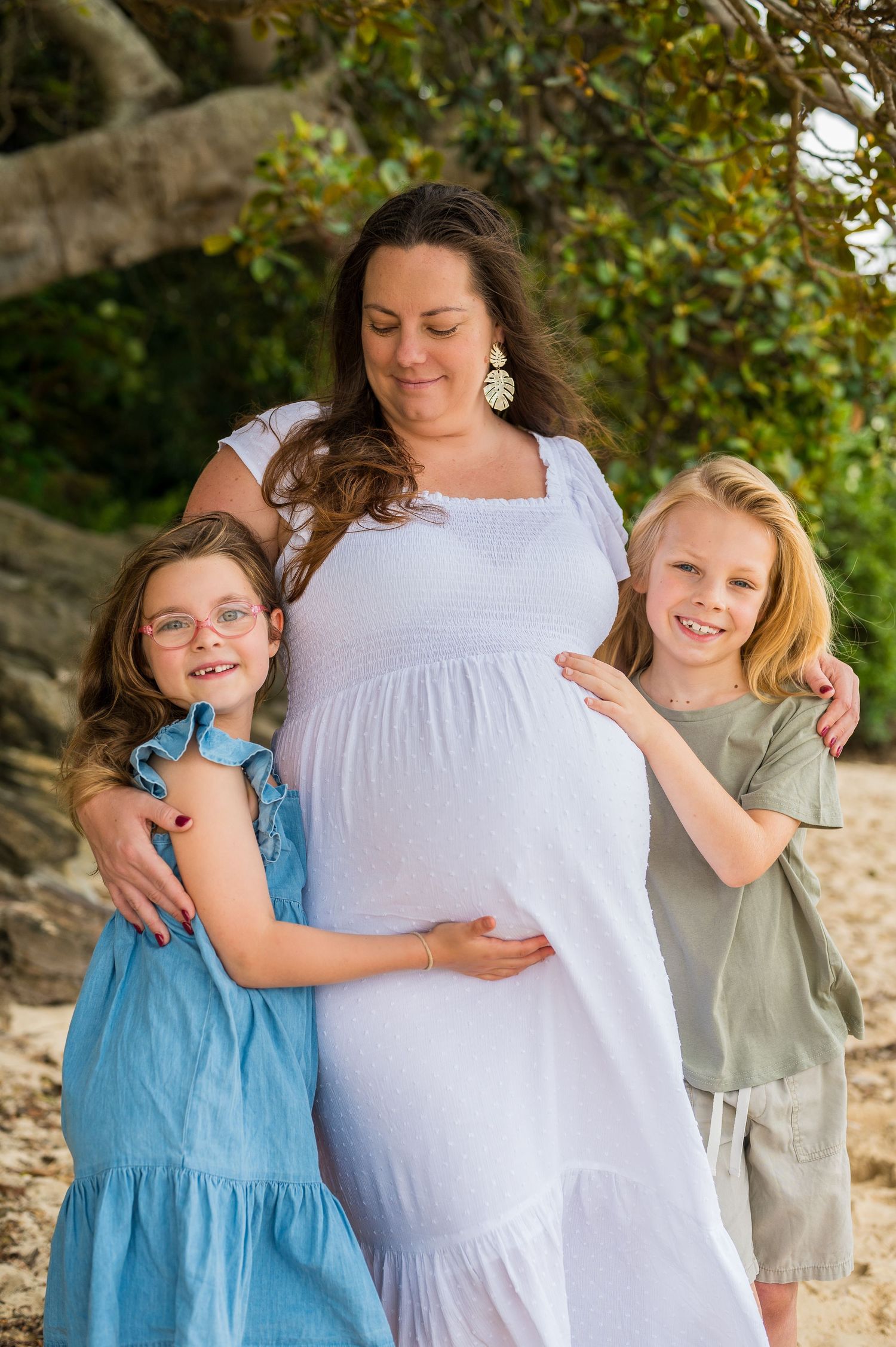 A heartwarming family maternity photo session outdoors shows loving embraces between mother and children in natural lighting.