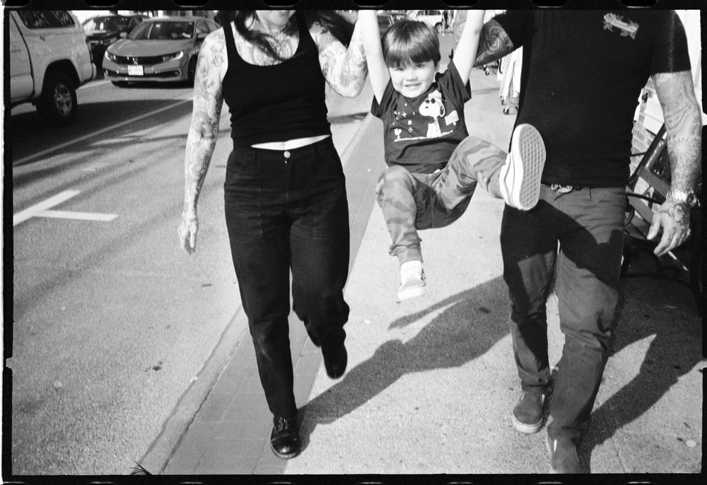 People walking together on a sidewalk in casual clothing.