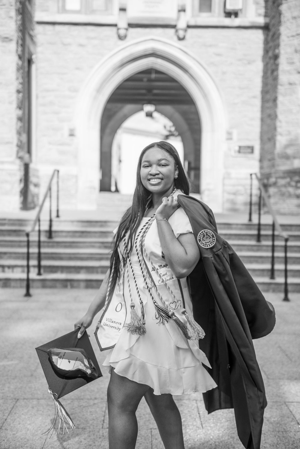 Black and white graduation photos showing joyful poses in front of stone archway.