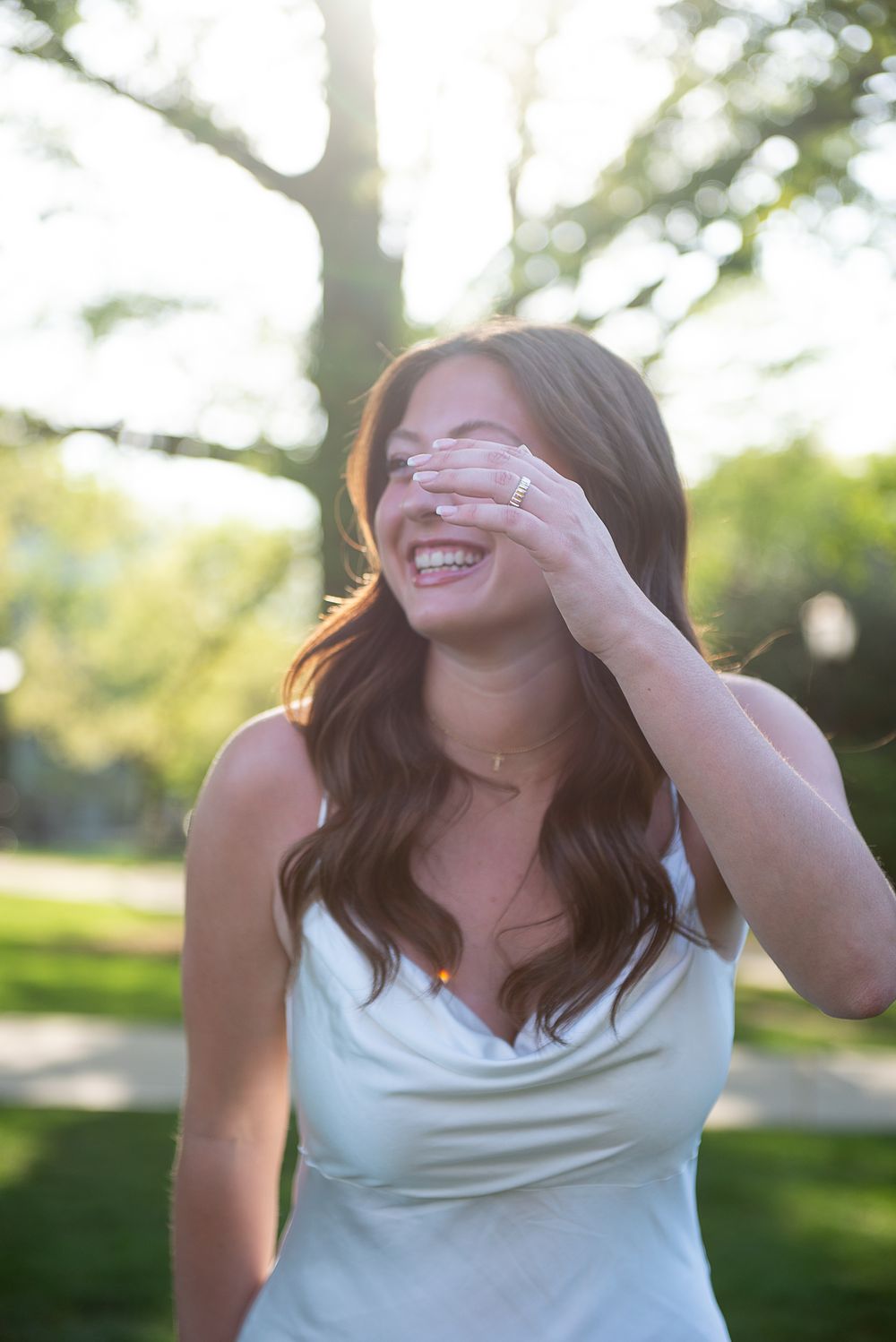 Candid outdoor portrait showing joyful laughter in natural lighting.