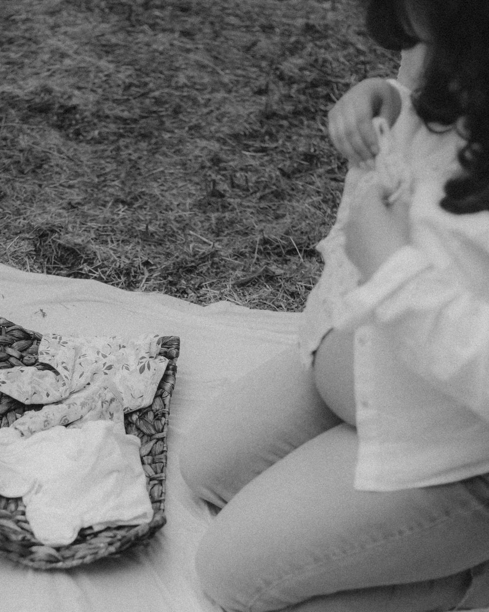 Black and white photograph of new mommy folding newborn clothes