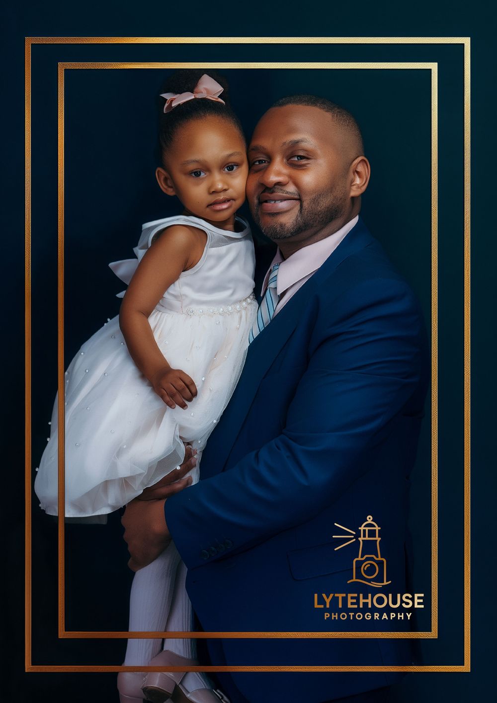 A tender moment captured in formal attire against a dark background with elegant gold frame border details.