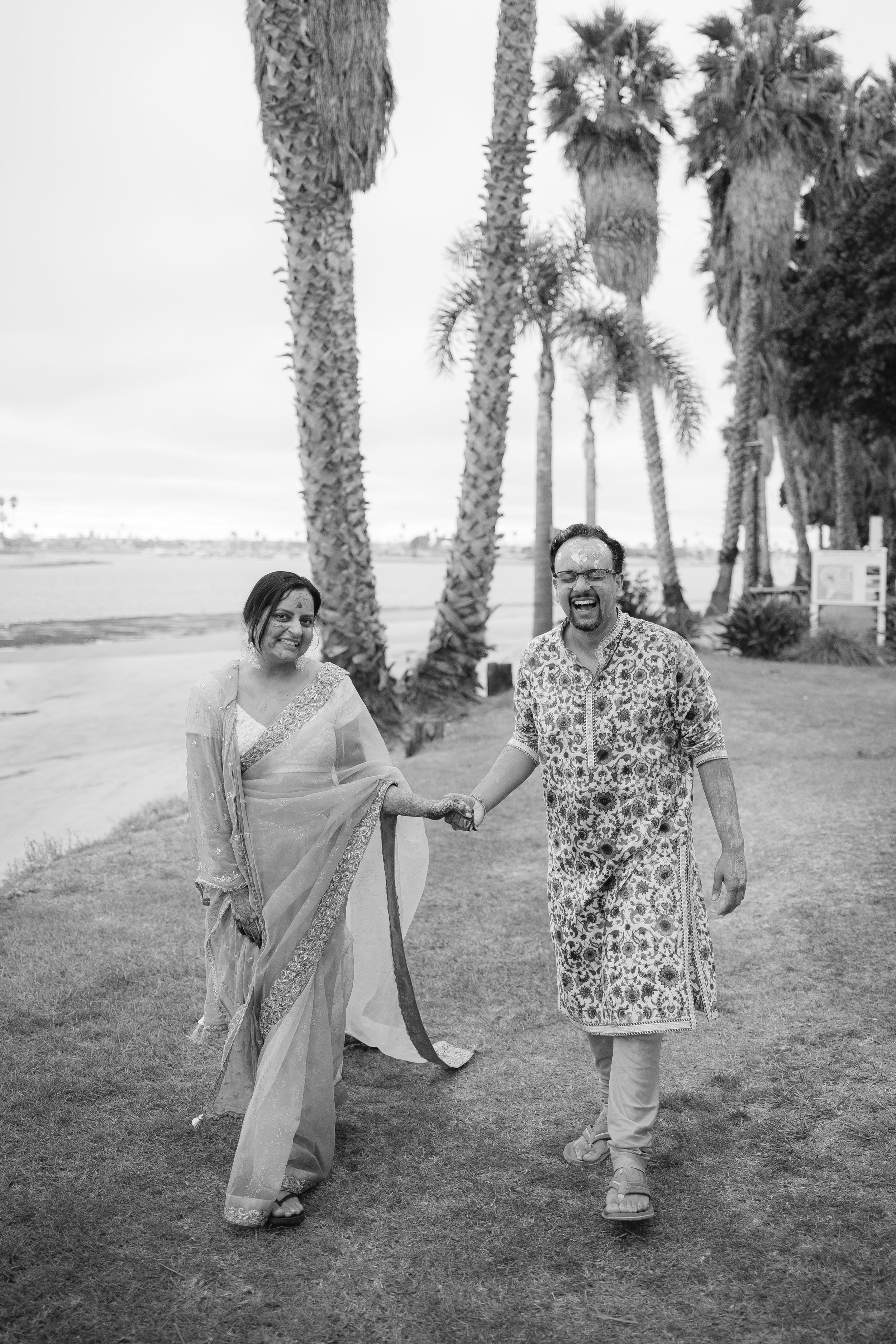 A playful black and white photo sequence of two people posing and dancing outdoors among palm trees.