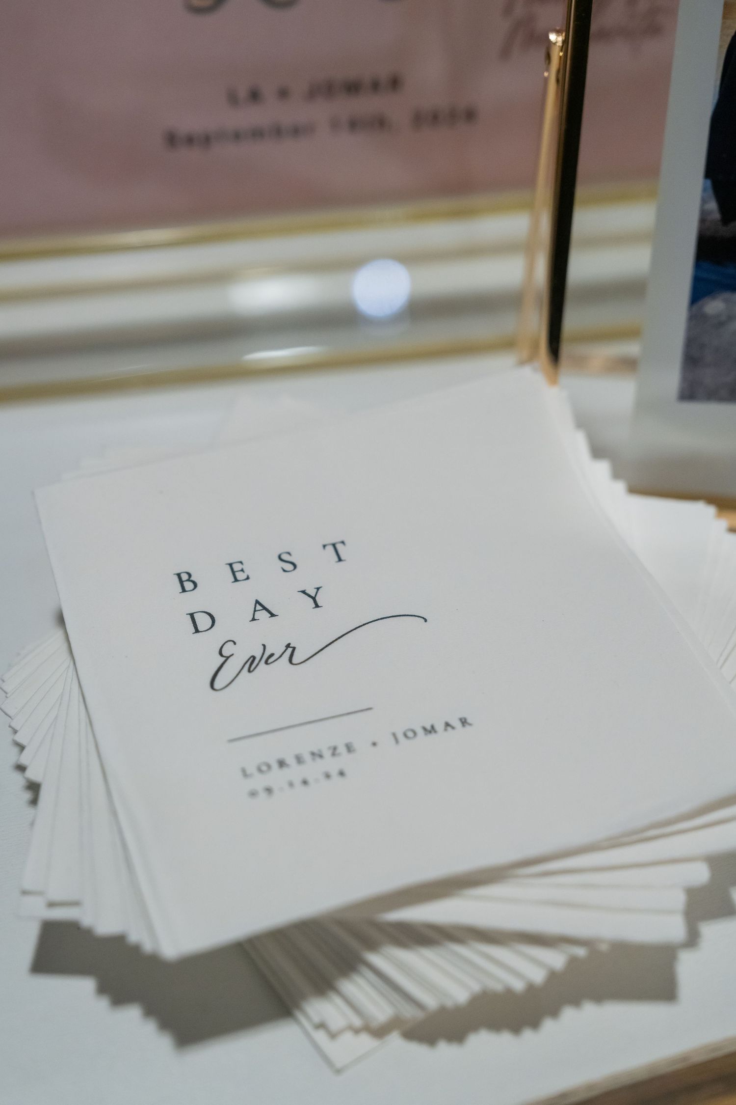 Custom wedding napkins printed with Best Day Ever and couple names Lorenze and Jomar, displayed at reception table.