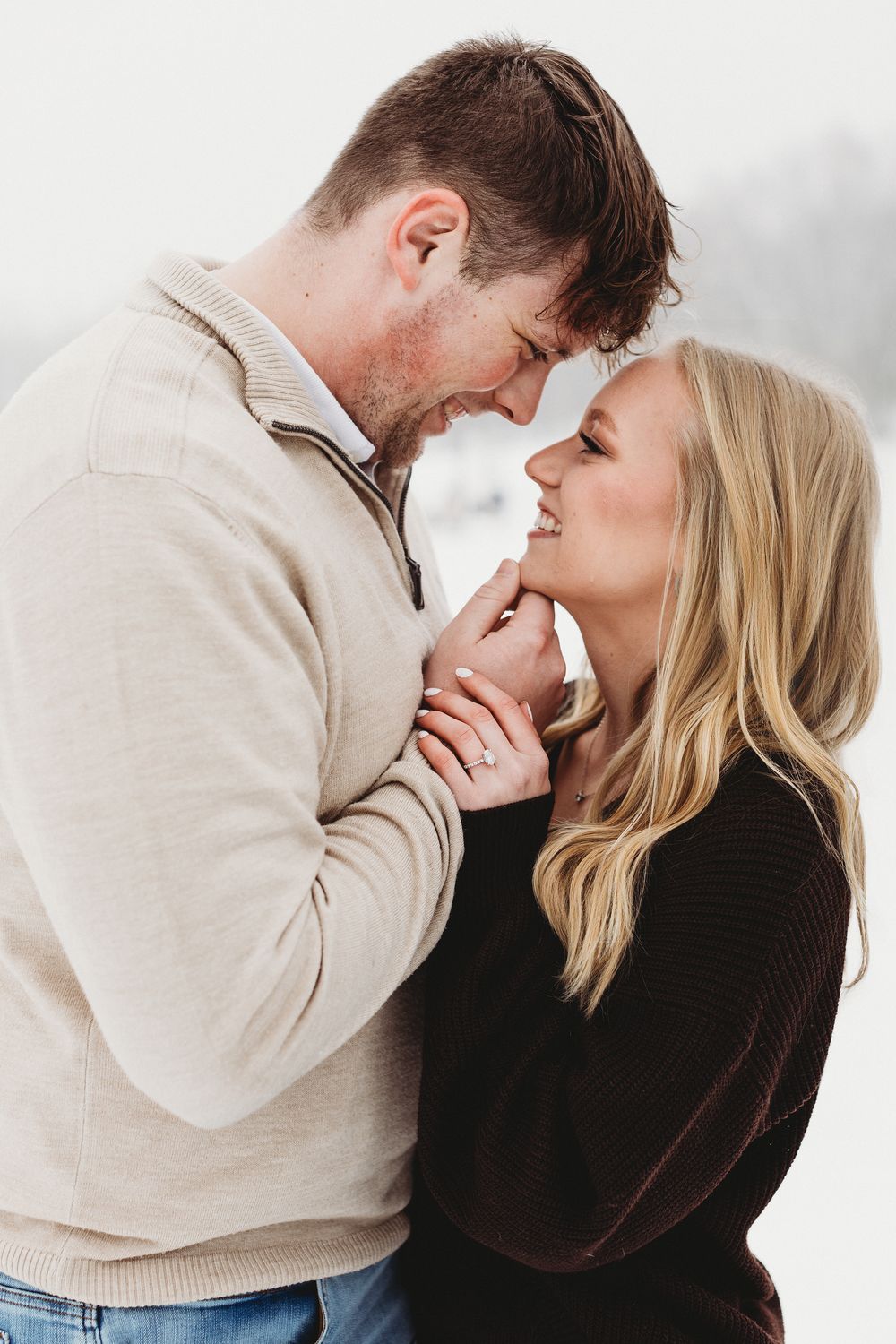 Romantic snowy engagement portrait in Maine with cozy couple and soft snowfall