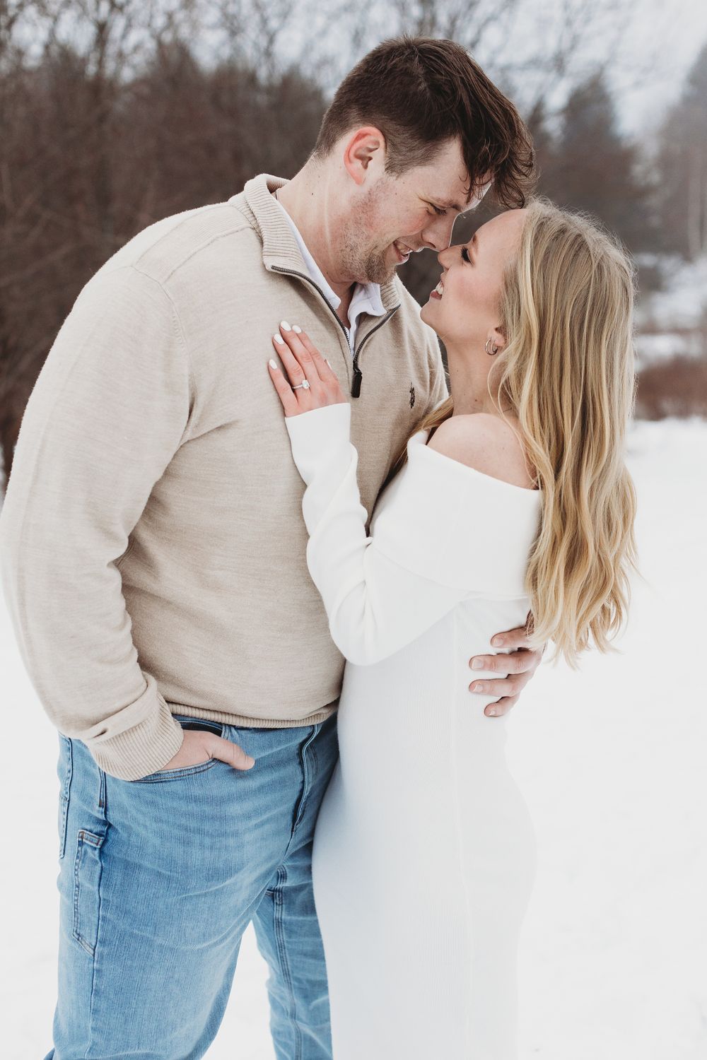 Maine engagement photo in snow with couple laughing together in a peaceful outdoor setting