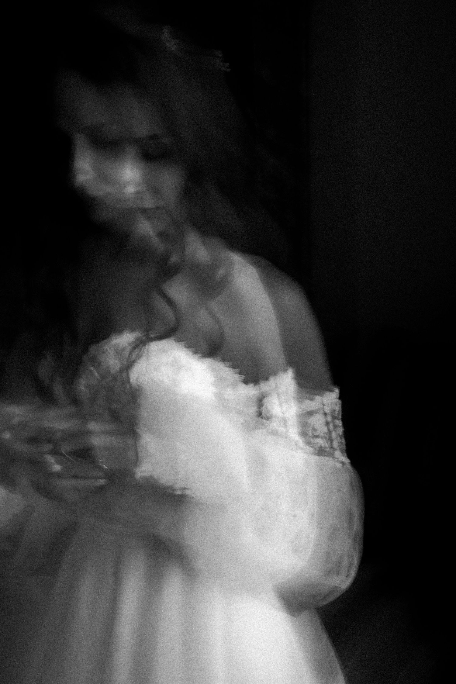 Black and white wedding portrait along stone pathway with elegant bride and groom.