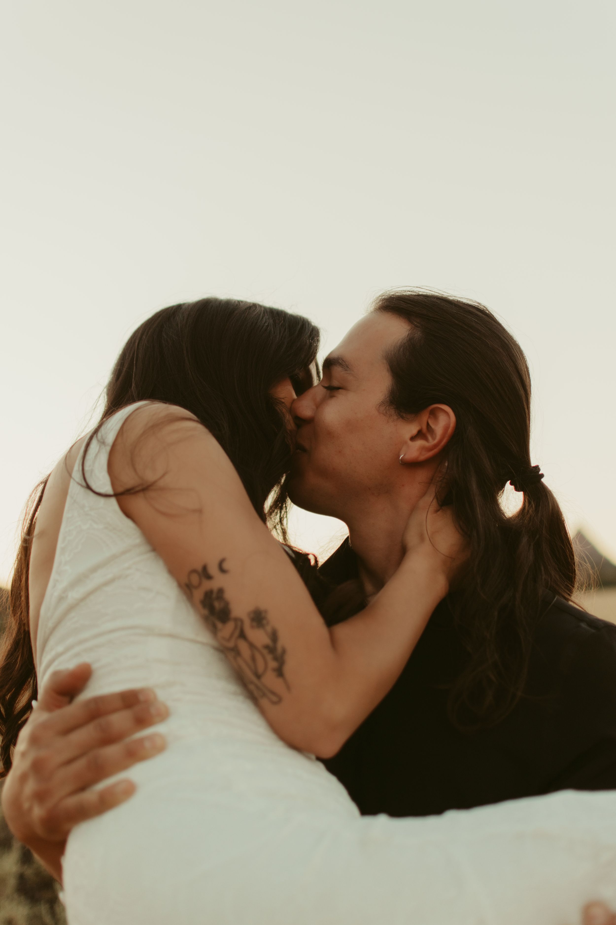 A romantic couple sharing an intimate moment against a soft light background.