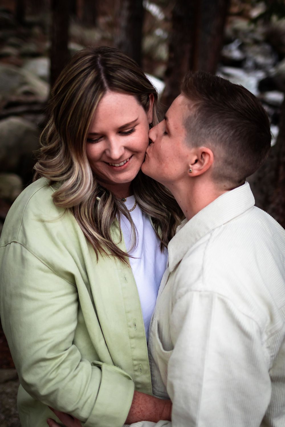 Intimate moment captured in a forest setting with natural lighting during an engagement photography in Idaho Springs, Colorado.