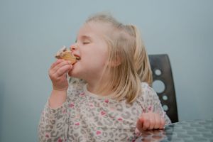 Child enjoying a delicious cookie with pure joy and delight.
