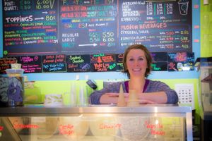 Colorful menu board with drinks and specials written in chalk behind a counter.
