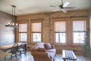 Cozy loft apartment interior with exposed brick walls, windows, and comfortable furniture.