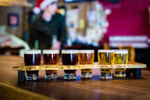 Beer flight sampler showing range of colors from light to dark in tasting glasses.