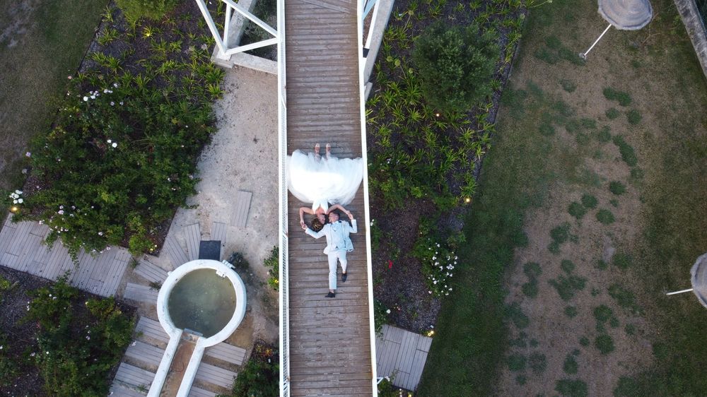Aerial view of white architectural structures with lush greenery.