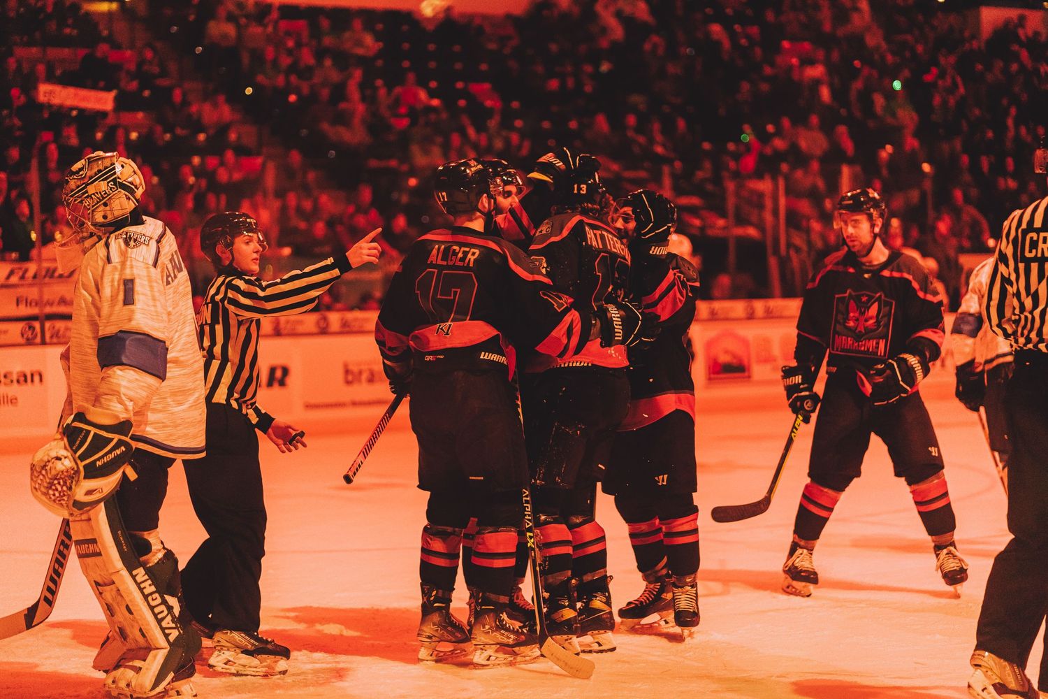 Hockey team celebrating on ice with orange-tinted lighting effect.