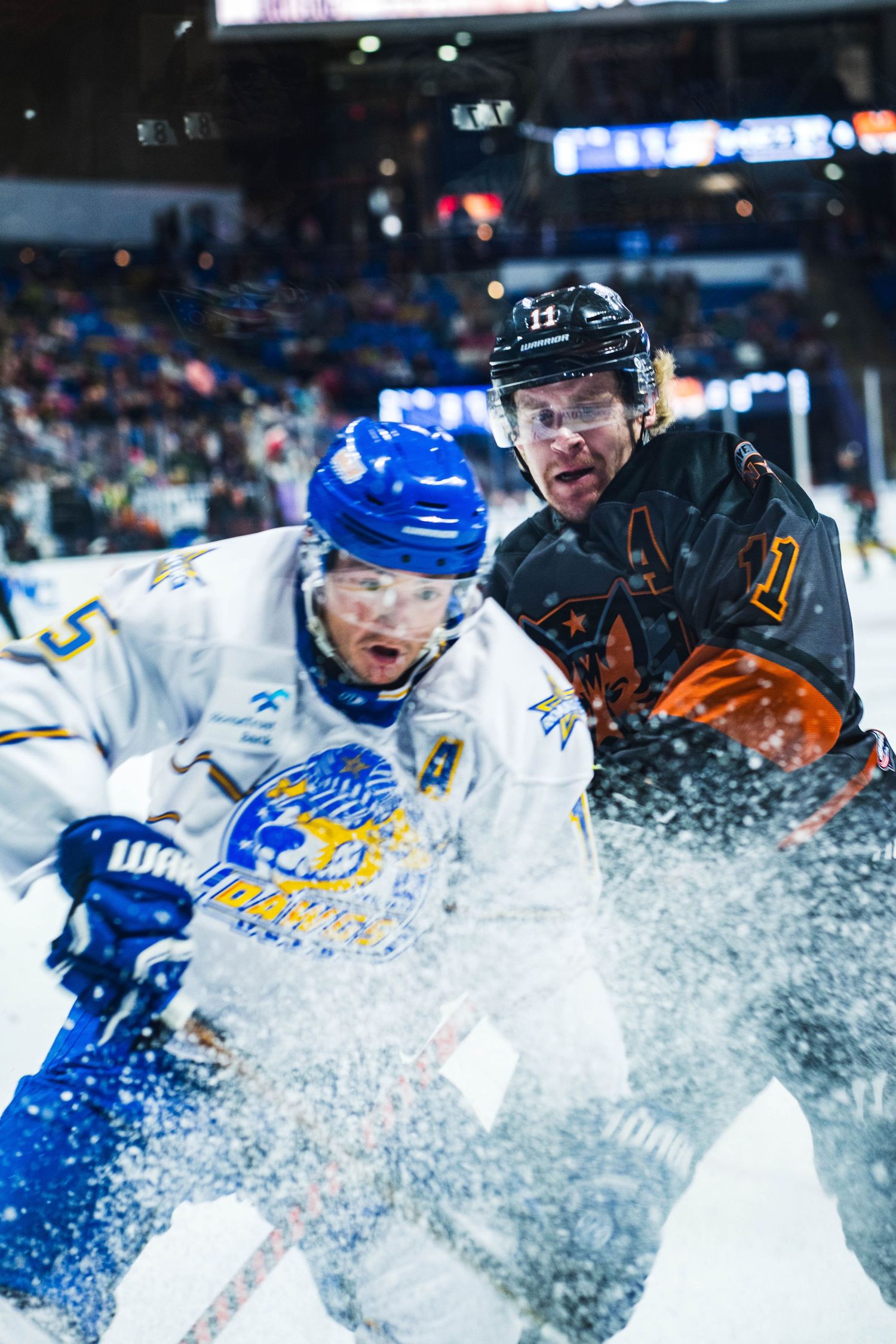 Hockey players collide in explosive ice spray during intense game action.