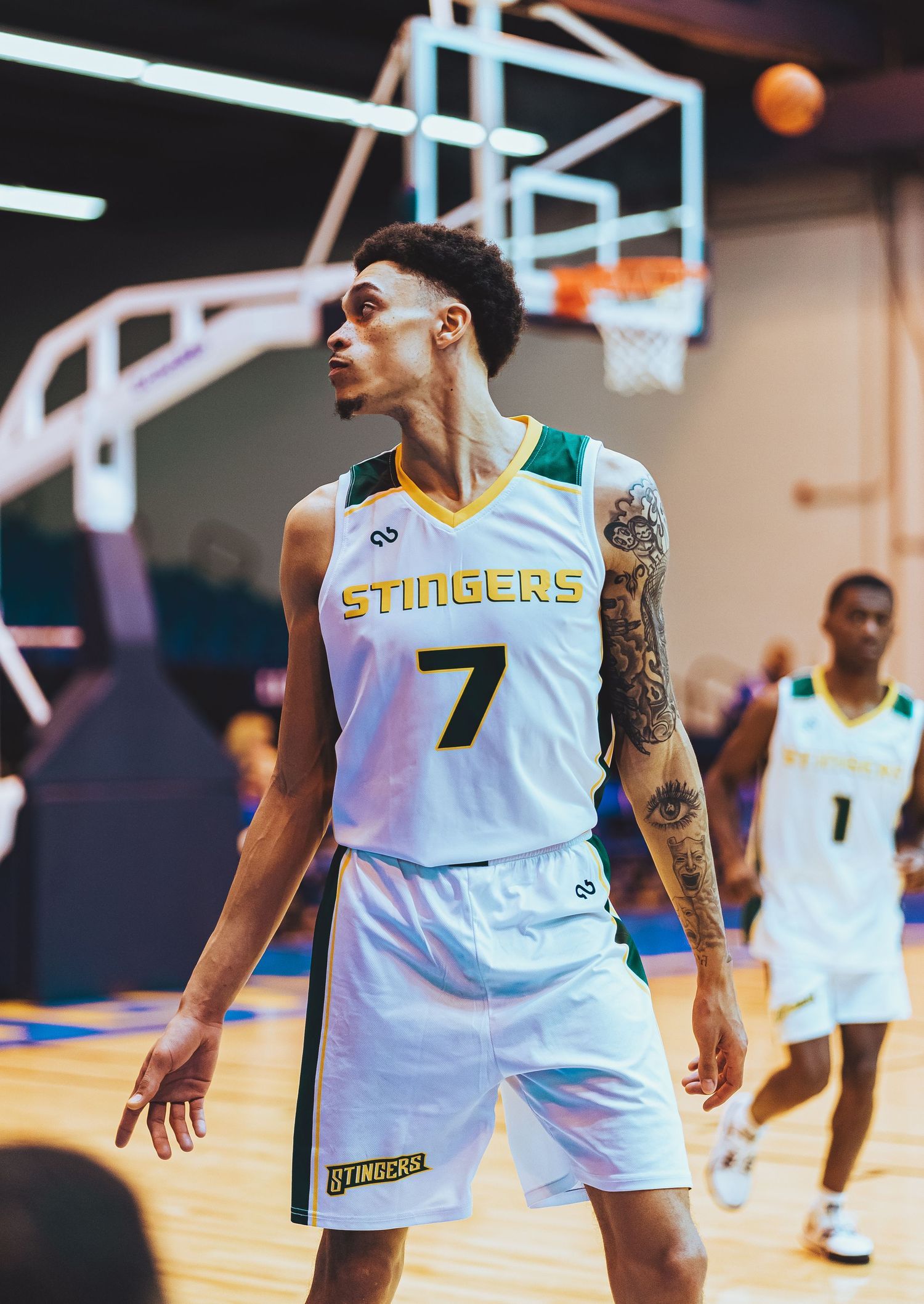 Basketball player in white Stingers jersey number 7 standing on court.
