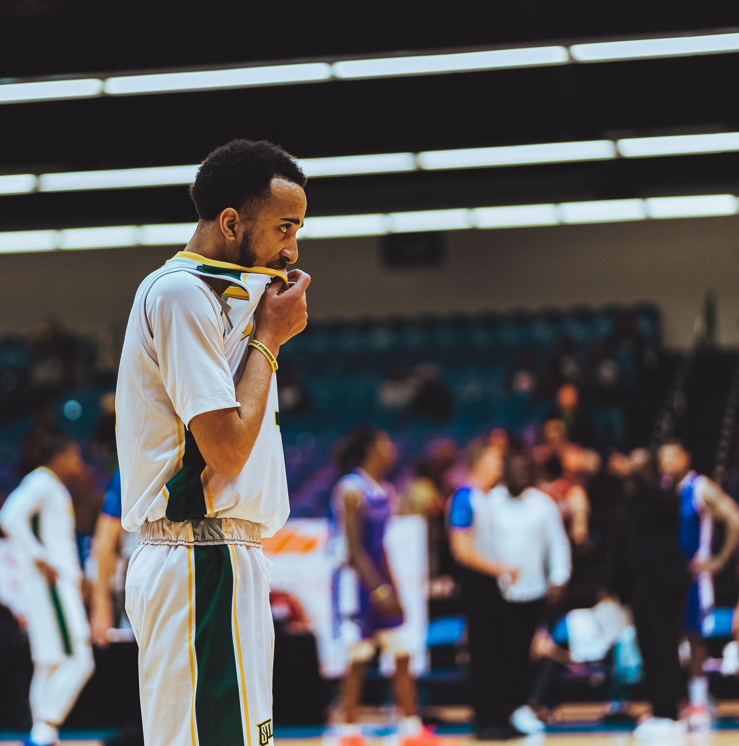 Basketball player in white uniform standing on court during game.