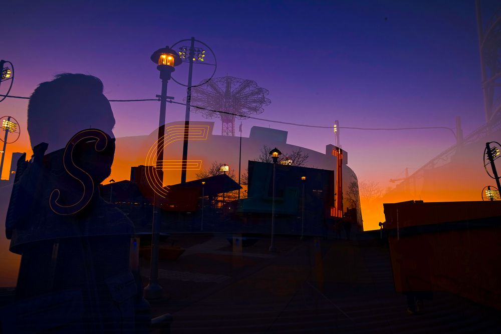 Silhouette of street lanterns against a dramatic orange and purple sunset sky.
