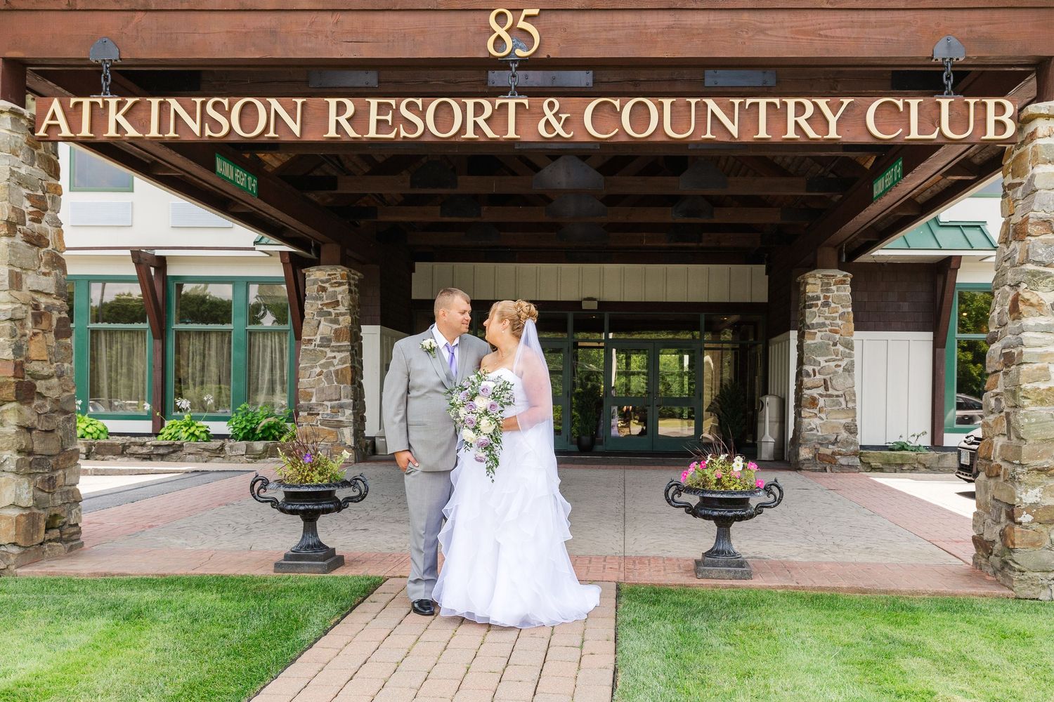 Wedding couple posing at entrance of Atkinson Resort & Country Club.