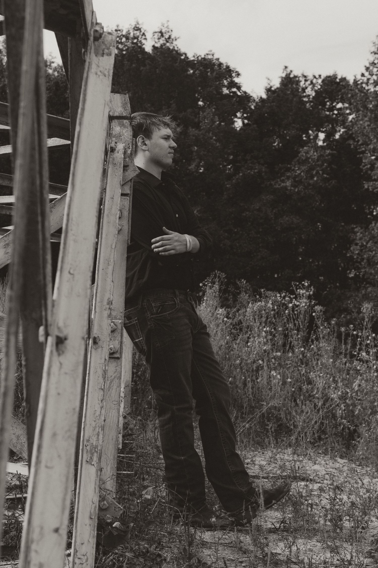 Black and white photo sequence showing someone climbing up a ladder against a wooden pole in a rural setting.