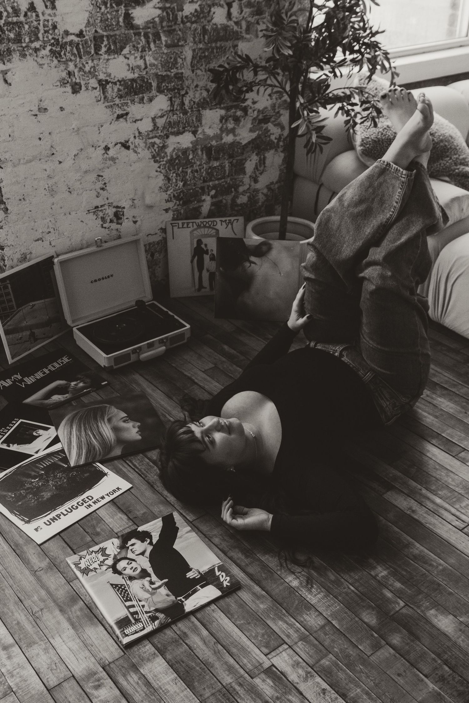 Black and white photo sequence showing someone lying on wooden floor reading a book in different positions.
