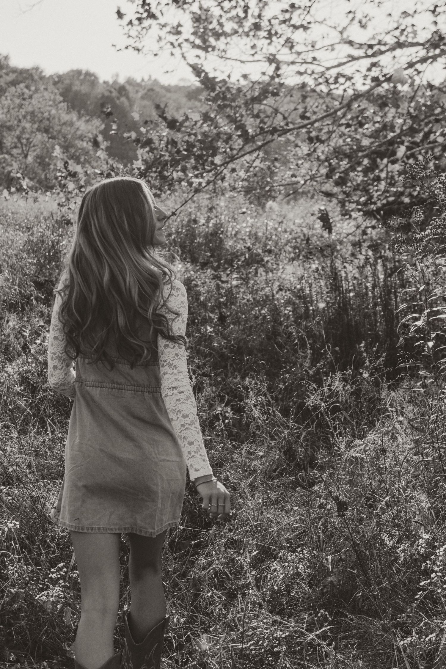 Black and white photo series showing a person walking through a natural outdoor setting with bushes and foliage.