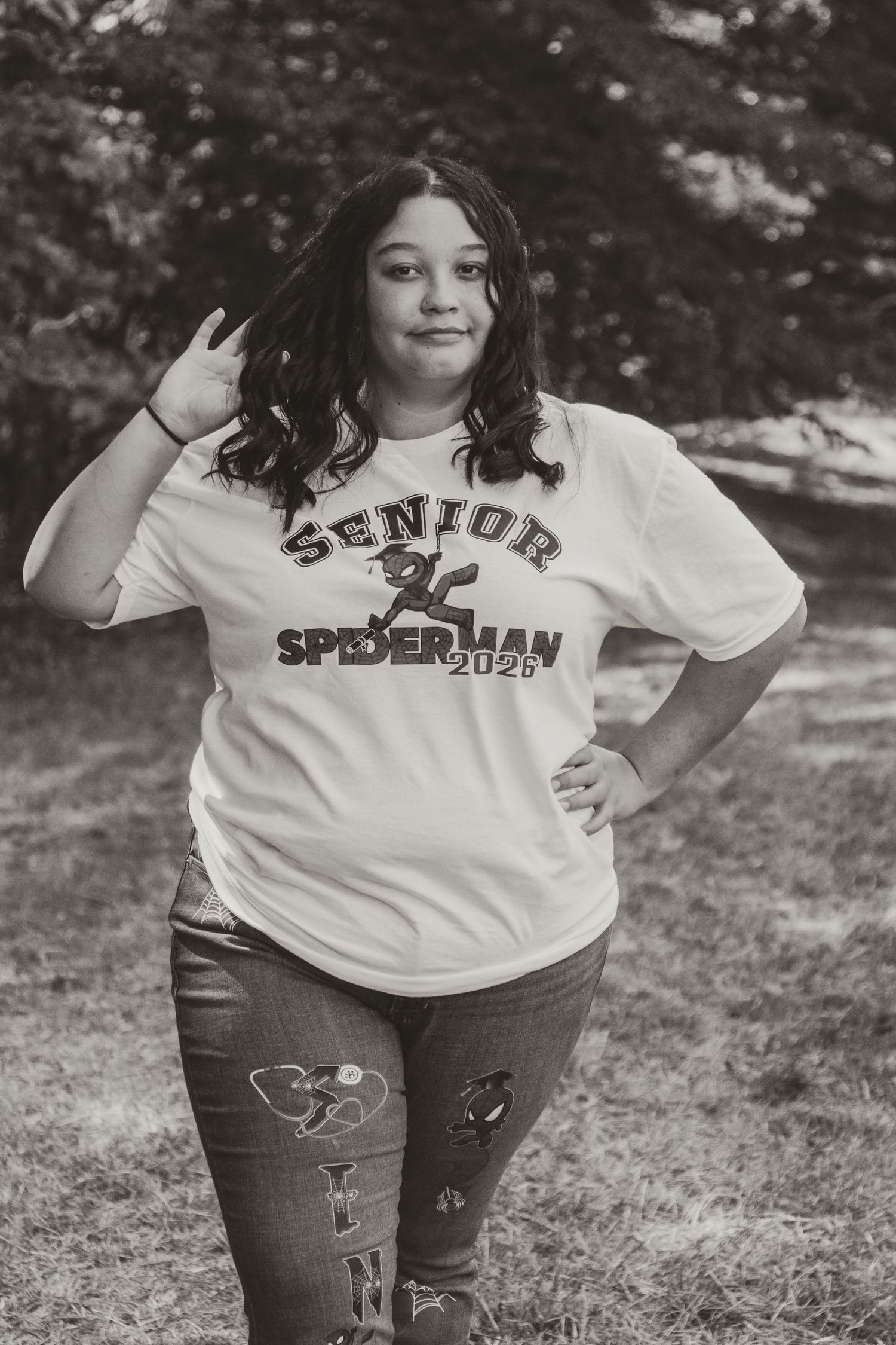 Black and white photo series showing a person in a Spider-Man themed senior class t-shirt posing outdoors.