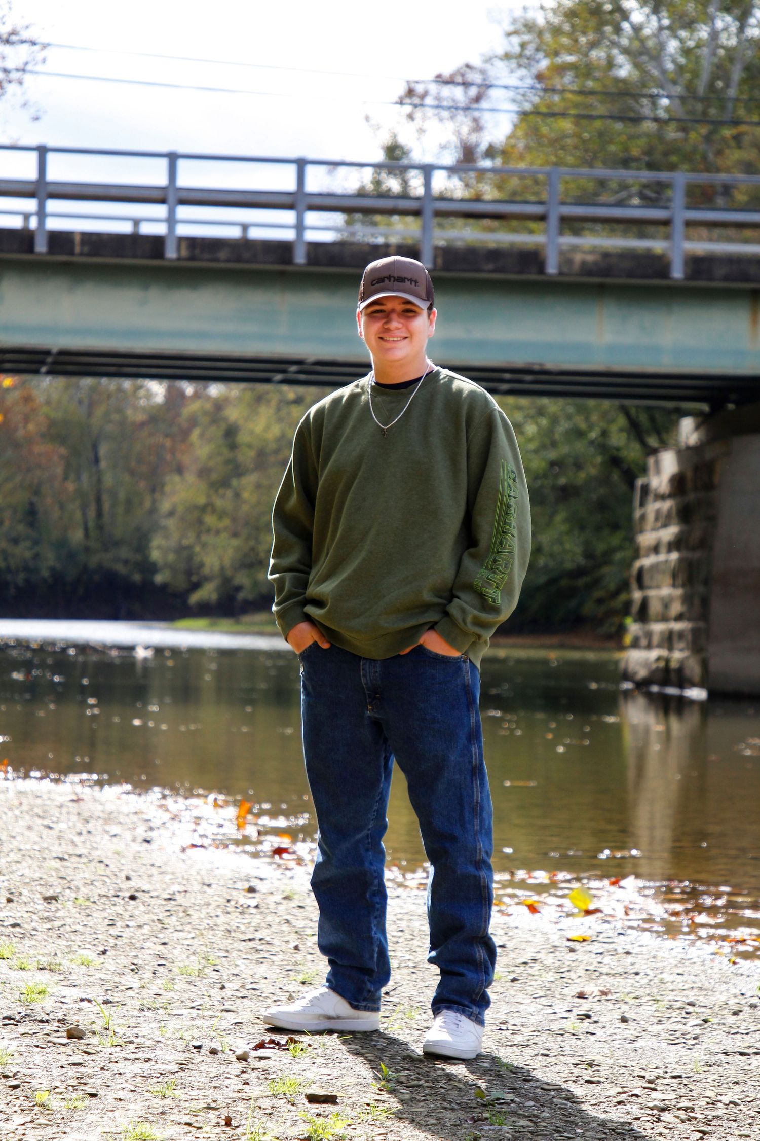 Casual autumn scene with bridge and river in background.